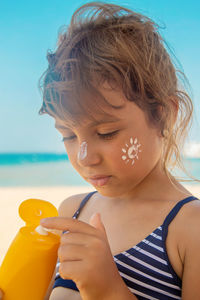 Close-up of young woman drinking straw at beach