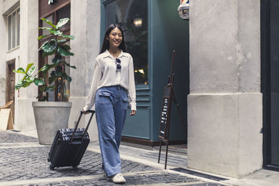 Portrait of smiling young woman walking on street