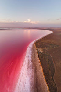 Vertical panoramic salty lake shore with pink salt at dusk after sunset. aerial view