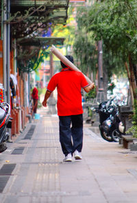 Rear view of people walking on footpath