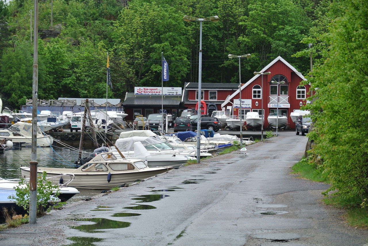 BOATS MOORED BY RIVER AGAINST BUILDINGS