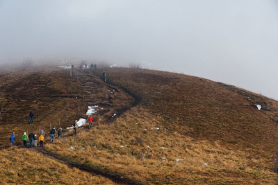 People on mountain against sky