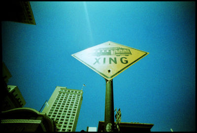 Low angle view of road signs against blue sky