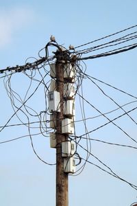 Low angle view of electricity pylon against clear sky