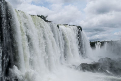 Scenic view of waterfall against sky