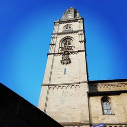 Low angle view of clock tower against clear blue sky