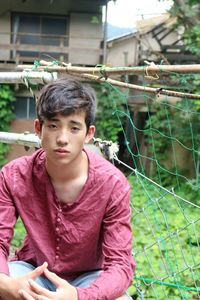 Portrait of teenage boy sitting outdoors