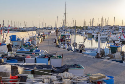 Boats moored at harbor against clear sky