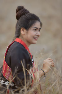 Side view of smiling young woman lying on field