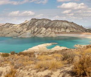 Scenic view of lake by mountain against sky