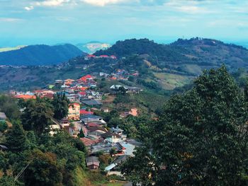 Scenic view of town by mountains against sky