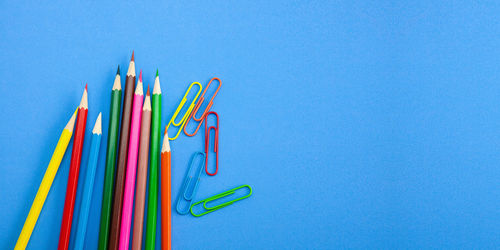 Close-up of multi colored pencils against blue background