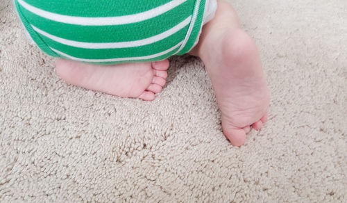 Low section of baby on carpet