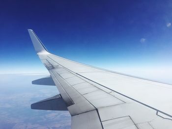 Airplane wing against blue sky