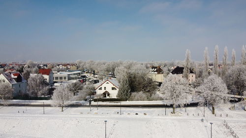 Panoramic view of buildings in town against sky during winter