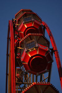 Low angle view of illuminated ferris wheel against blue sky