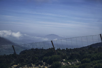 Scenic view of suspension bridge over mountain against sky