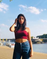 Young woman wearing hat standing against sky