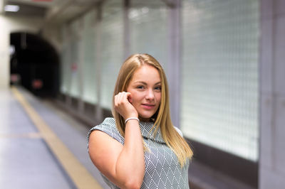 Young woman using mobile phone while standing in bus