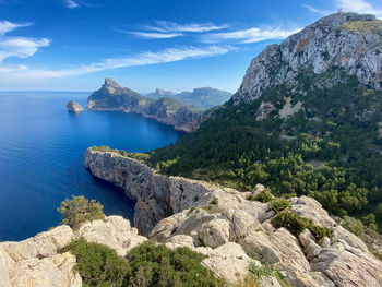 Scenic view of sea by mountains against sky