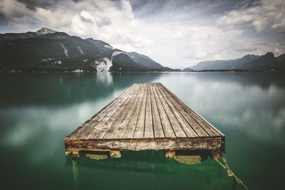 Scenic view of lake by mountains against sky