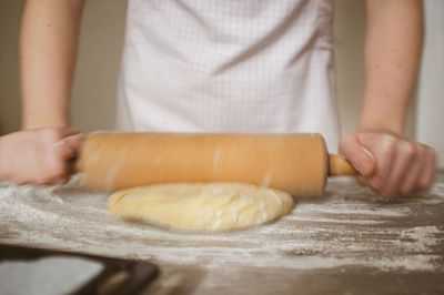 Midsection of woman making flatbread in kitchen