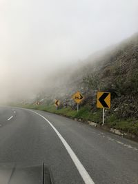 Road leading towards mountains against sky