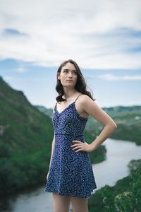 Portrait of beautiful young woman standing against sea