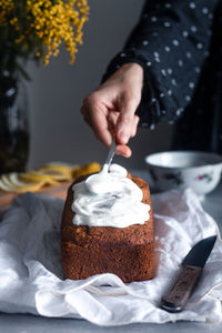 Midsection of man holding ice cream on table