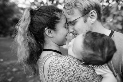 Cheerful couple with child standing outdoors