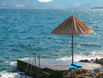 Parasol at jetty against mountains