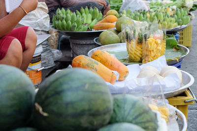 Midsection of person preparing fruits for sale in market