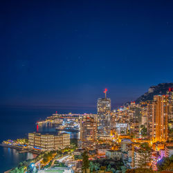 Illuminated buildings against sky at night