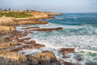 Scenic view of rocks on beach against sky