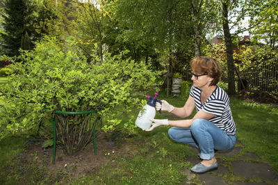 Side view of woman sitting in park