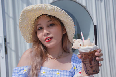 Portrait of smiling young woman wearing hat.