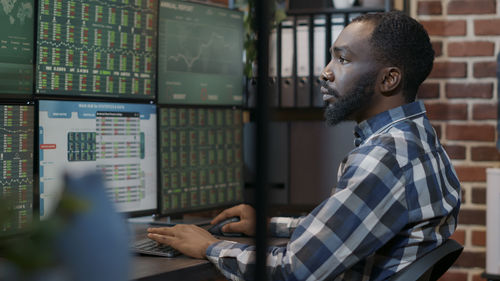 Side view of stock trader working at office