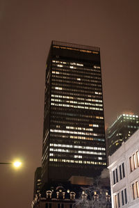 Low angle view of illuminated buildings against sky at night