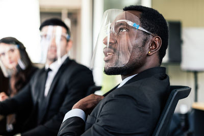 Businesspersons wearing face shield during meeting