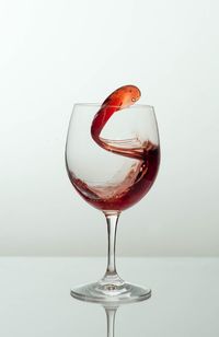 Close-up of wineglass against white background