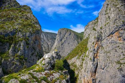 Low angle view of rocks on mountain against sky