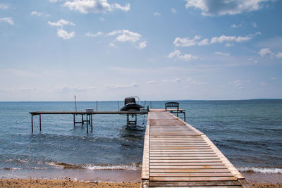 Pier over sea against sky at beach