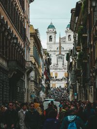 People on street amidst buildings in city