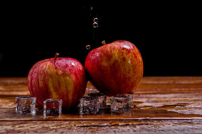 Close-up of apples on table against black background