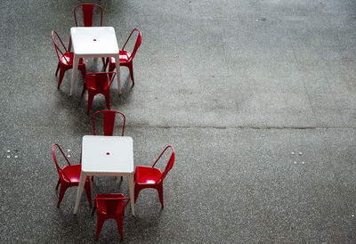 High angle view of empty chairs on table against wall