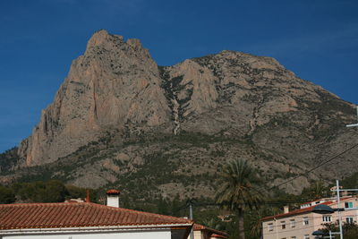 Low angle view of house and mountains against clear sky