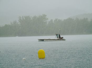 People in boat on river during rainy season