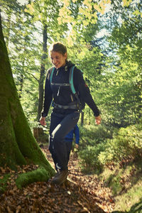 Full length of smiling woman in forest