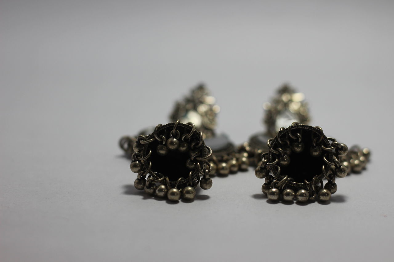 CLOSE-UP OF NECKLACE ON TABLE AGAINST WHITE BACKGROUND