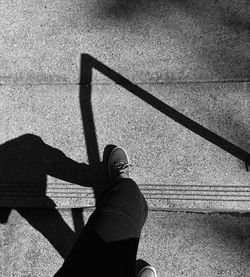 Low section of woman shadow on concrete road